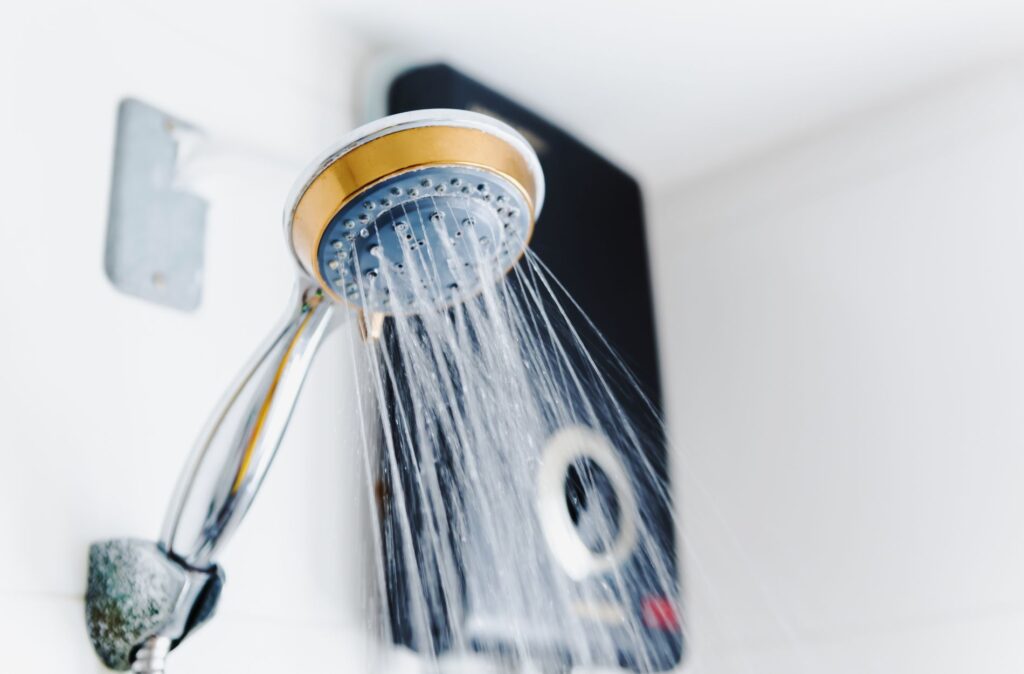 What's Causing Your Water Heater's Pilot Light to Go Out in Sidney? 10 Showerhead with water flowing, representing home water heating systems related to HVAC services in Sidney.